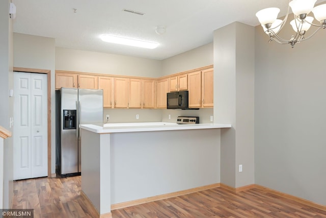 kitchen featuring black microwave, stainless steel refrigerator with ice dispenser, light brown cabinets, and light wood-style floors