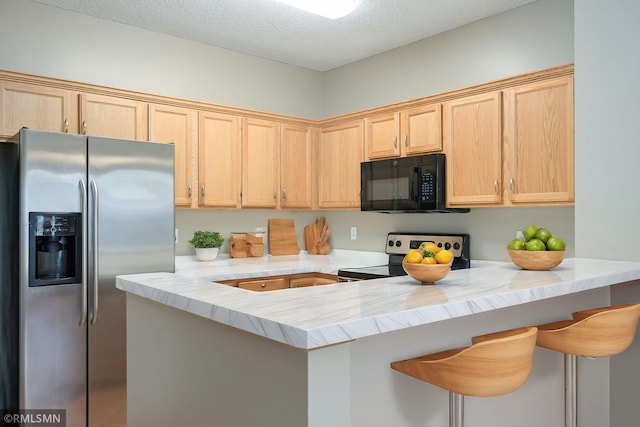 kitchen with a kitchen breakfast bar, a peninsula, stainless steel appliances, light countertops, and light brown cabinets