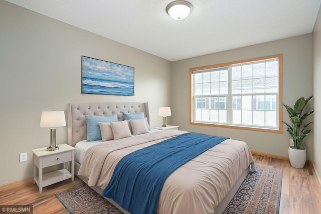 bedroom with light wood-style flooring and baseboards