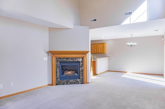 unfurnished living room with light carpet, a fireplace, visible vents, and baseboards