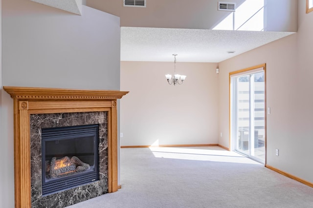 carpeted living room featuring visible vents, a textured ceiling, baseboards, and a premium fireplace