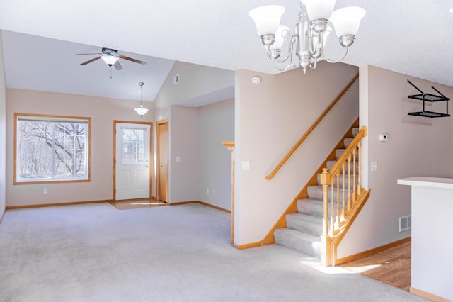 interior space featuring lofted ceiling, baseboards, stairs, and light colored carpet