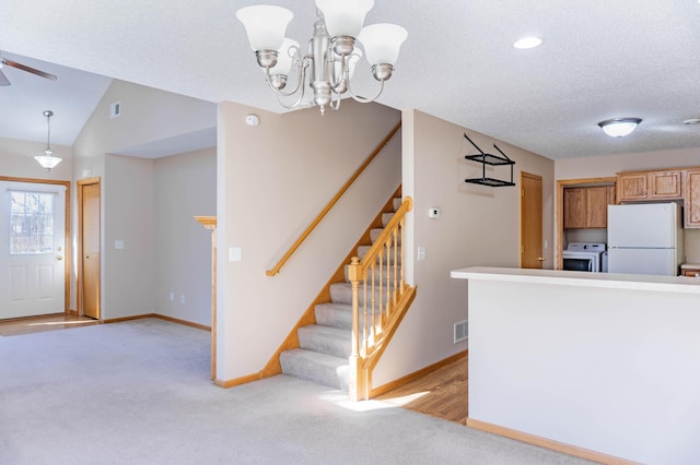 kitchen with freestanding refrigerator, washer / clothes dryer, light carpet, and baseboards