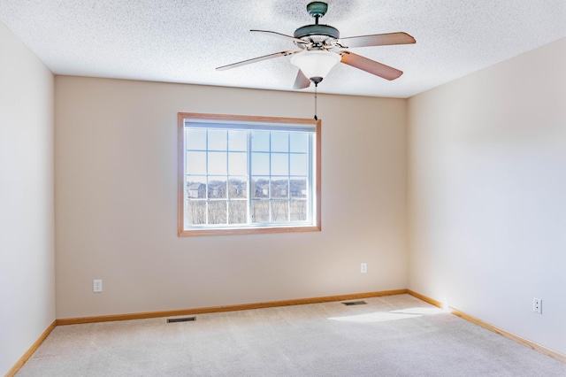 unfurnished room featuring baseboards, a textured ceiling, visible vents, and carpet flooring