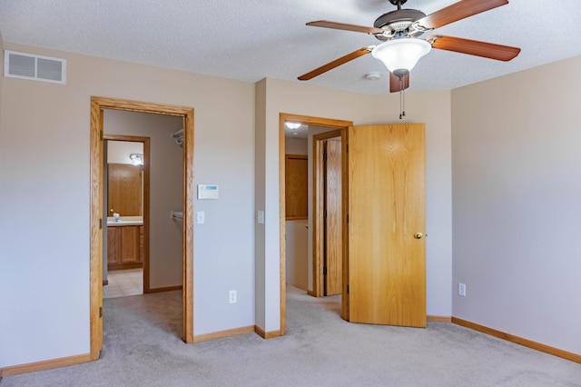 unfurnished bedroom with baseboards, visible vents, a textured ceiling, and carpet flooring