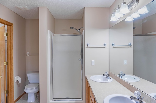 bathroom with a shower stall, a textured ceiling, and a sink