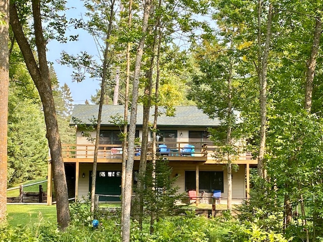 rear view of house with a yard and a wooden deck