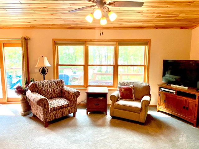 living area with a ceiling fan, wooden ceiling, and carpet floors