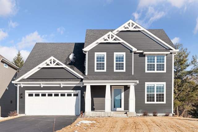 view of front facade featuring aphalt driveway, a garage, and covered porch