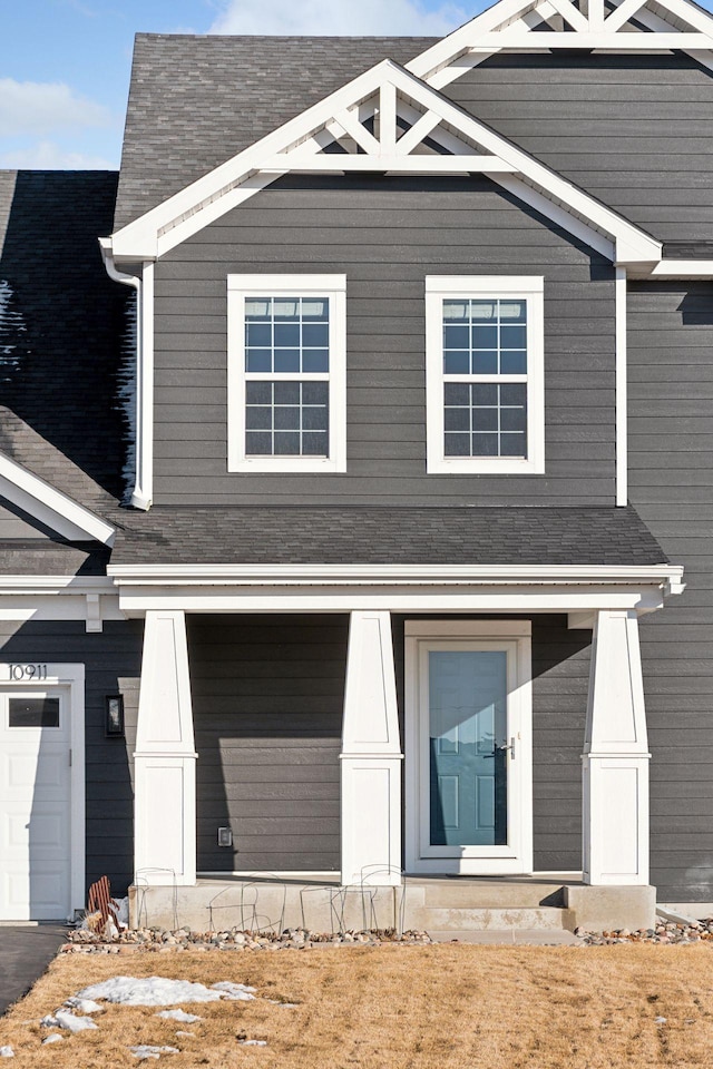 view of front facade with roof with shingles