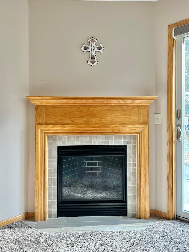 details featuring carpet, baseboards, and a tile fireplace