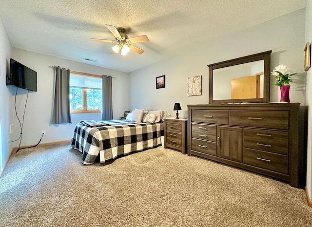 bedroom with a ceiling fan, light carpet, a textured ceiling, and baseboards