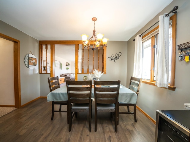 dining area featuring baseboards, an inviting chandelier, and wood finished floors