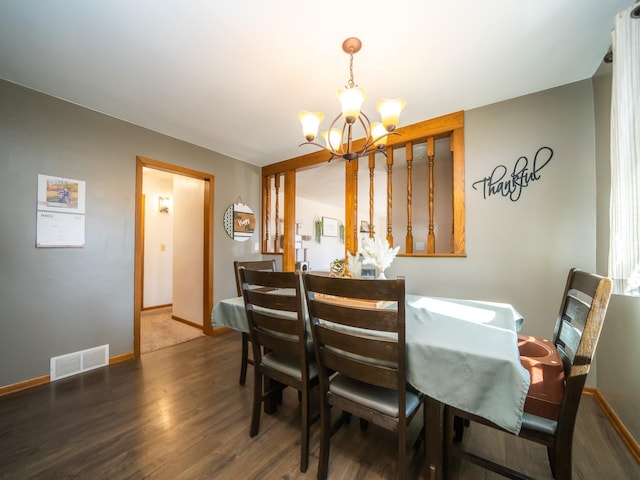 dining area with visible vents, baseboards, an inviting chandelier, and wood finished floors