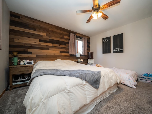 bedroom with wooden walls, a ceiling fan, and carpet floors