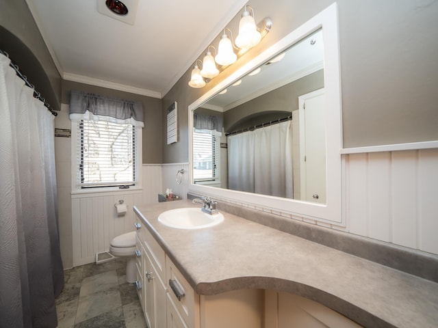 full bathroom with visible vents, toilet, ornamental molding, wainscoting, and vanity