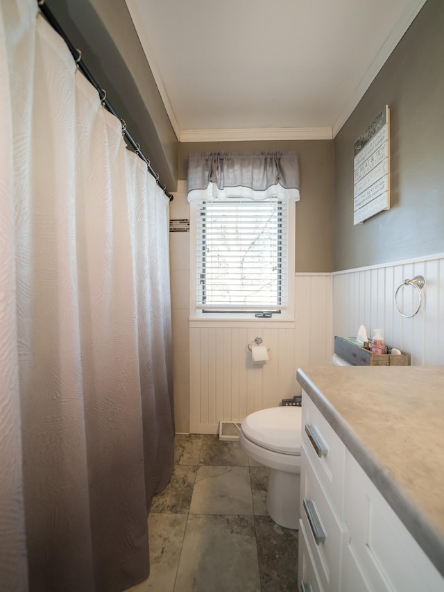 full bathroom with vanity, toilet, a wainscoted wall, and ornamental molding