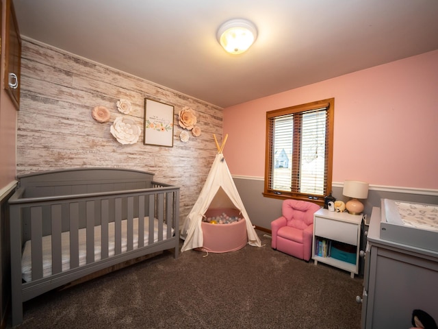 carpeted bedroom with an accent wall and a nursery area