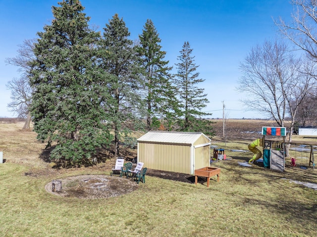 view of yard with a storage shed, an outdoor structure, and a playground