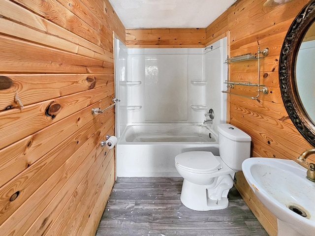 full bathroom with a sink, wood finished floors, toilet, and wooden walls