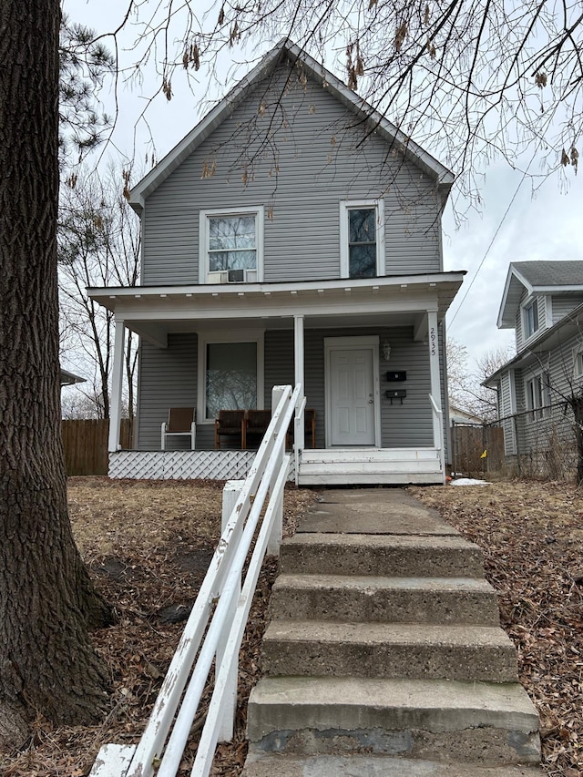 view of front of home featuring a porch and fence