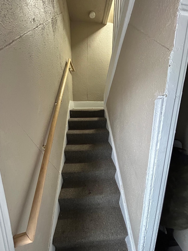 staircase featuring baseboards