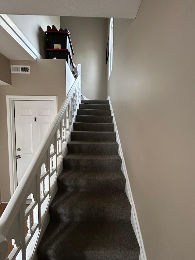 stairway featuring carpet, visible vents, and baseboards