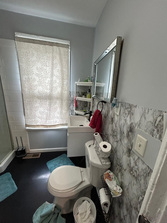 full bathroom featuring toilet, visible vents, walk in shower, and tile walls