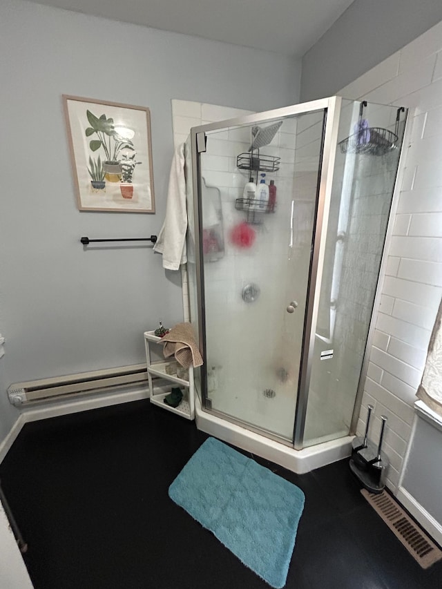 bathroom featuring a baseboard heating unit, visible vents, and a shower stall