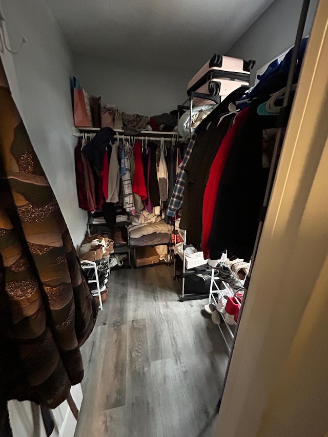 walk in closet with wood finished floors