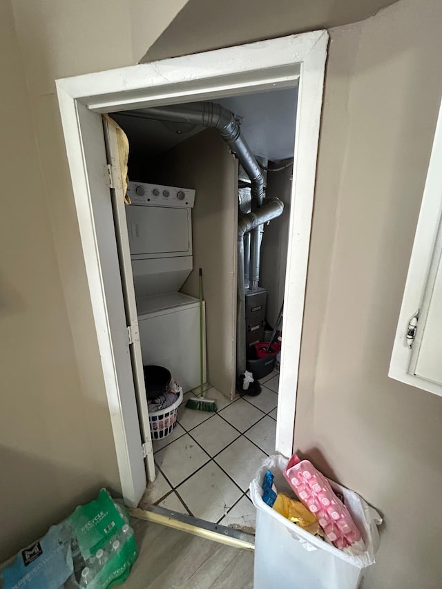 utility room with stacked washer and clothes dryer