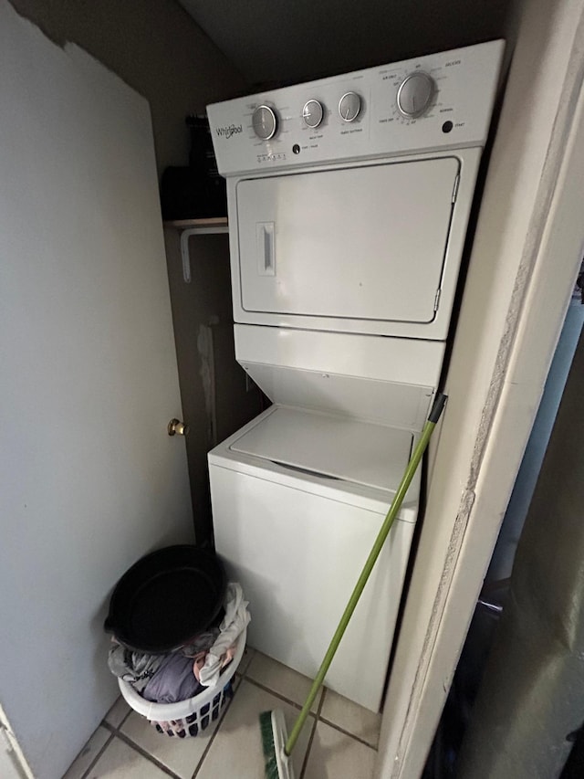 laundry room featuring stacked washer and dryer, tile patterned flooring, and laundry area