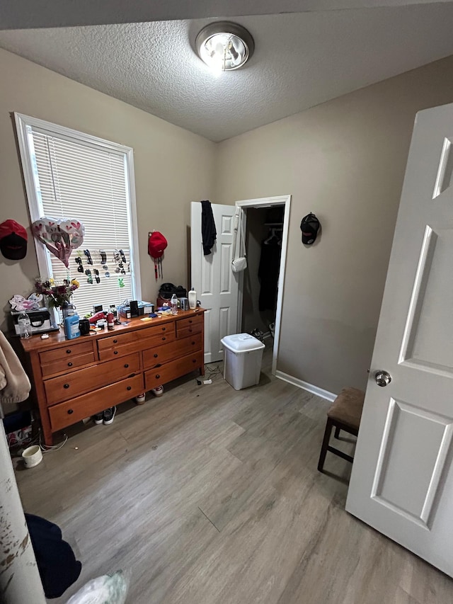 bathroom featuring a textured ceiling, wood finished floors, vanity, and baseboards