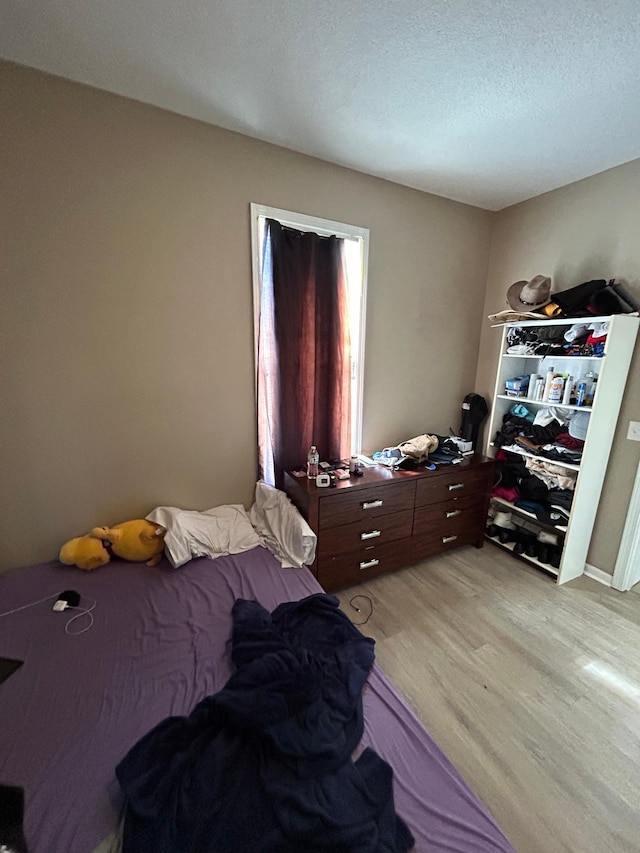 bedroom featuring a textured ceiling and light wood-style floors