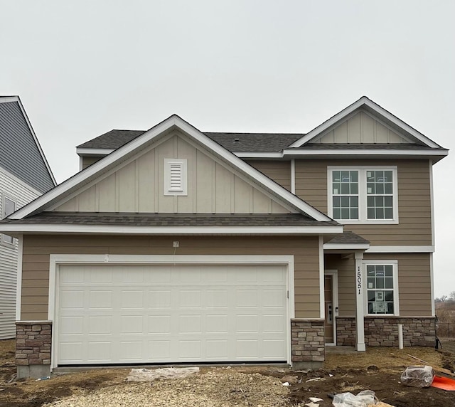 craftsman inspired home featuring a garage, stone siding, board and batten siding, and roof with shingles