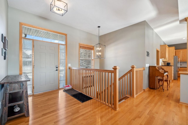 foyer featuring light wood-type flooring and a notable chandelier