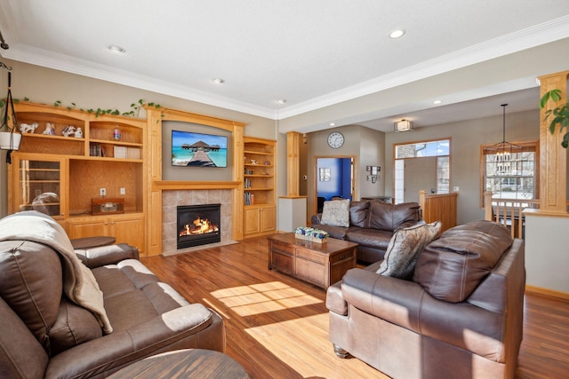 living area featuring ornamental molding, wood finished floors, and a tile fireplace