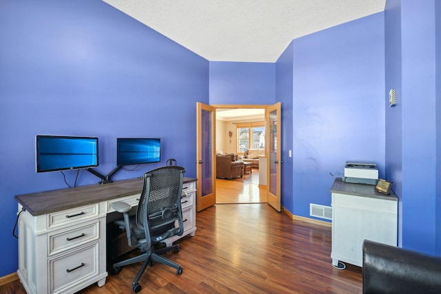 office featuring visible vents, baseboards, dark wood finished floors, and french doors