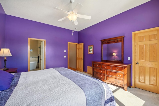 carpeted bedroom with ensuite bath and a ceiling fan