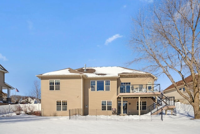 snow covered property with stairway, a deck, and fence