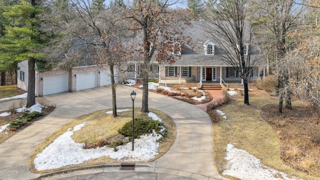 cape cod house featuring driveway, a garage, and brick siding