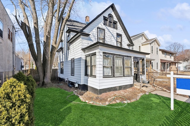 view of front of property featuring a chimney, a front lawn, and fence