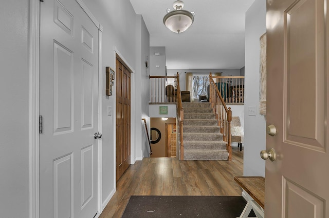 entryway featuring stairs, baseboards, and wood finished floors