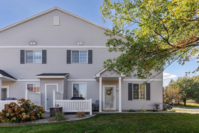 view of front of home with a deck and a front lawn