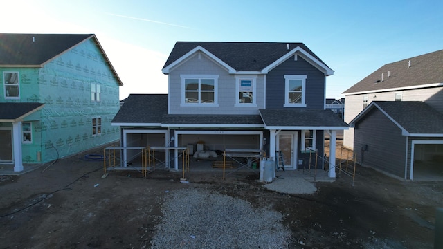 back of house with a shingled roof