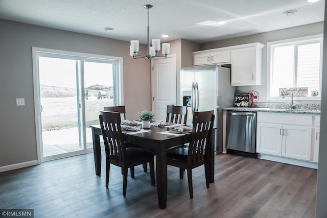 dining area with baseboards, dark wood-type flooring, and a notable chandelier