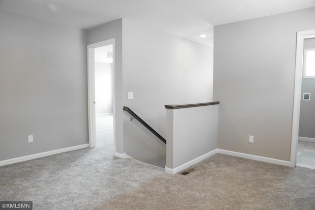 corridor featuring visible vents, an upstairs landing, recessed lighting, carpet, and baseboards