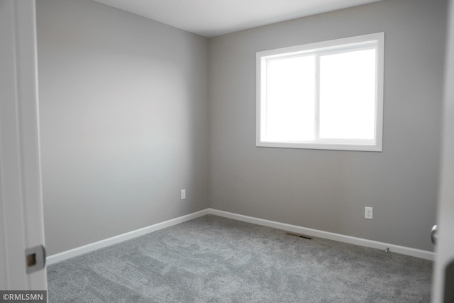 unfurnished room with carpet flooring, visible vents, and baseboards