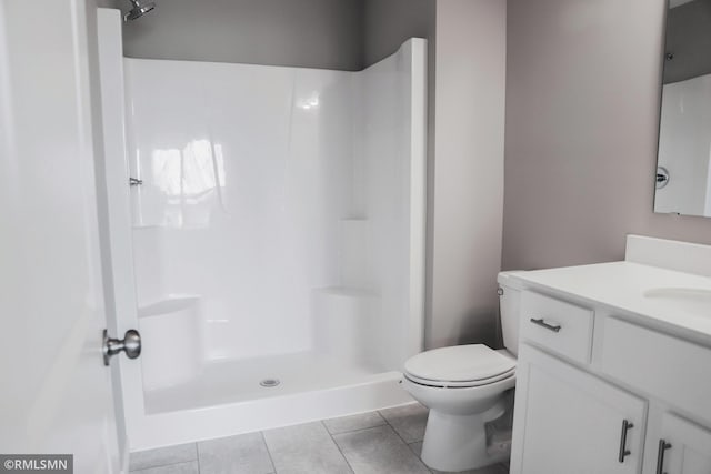 full bath with tile patterned floors, toilet, vanity, and a shower