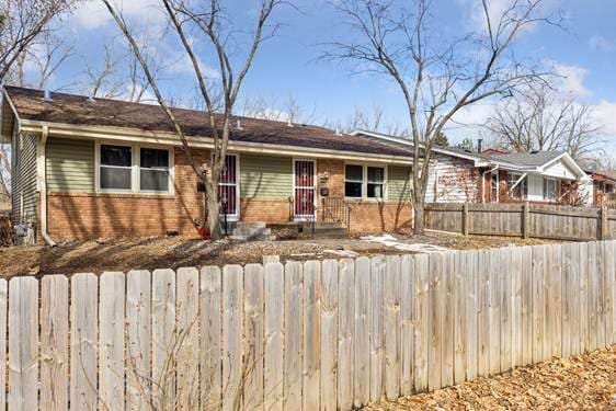 ranch-style house with brick siding and a fenced front yard